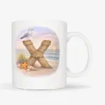 Mok met afbeelding van strand thema; letter X van hout met op de letter een meeuw. De mok heeft een standaard oor.