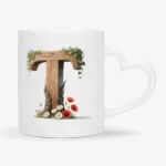 Witte mok met een opdruk van een houten letter T met klaprozen, bloemen en klimop.