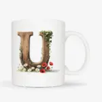 Witte mok met een opdruk van een houten letter U met klaprozen, bloemen en klimop.