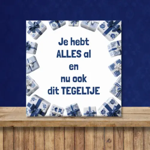 Tegeltje met de tekst: "Je hebt alles al en nu ook dit tegeltje" en cadeautjes er om heen in Delfts blauwe stijl ter decoratie